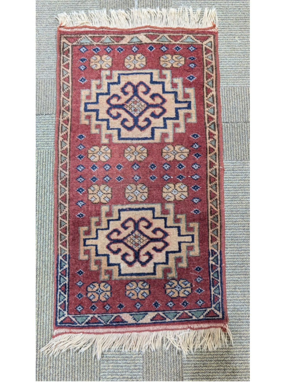 Small hand-knotted wool rug featuring bold geometric medallions 2.25 x 1.25 ft